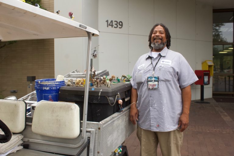 man smiling and standing next to his decorated golf cart