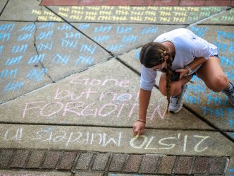 student uses chalk on the sidewalk
