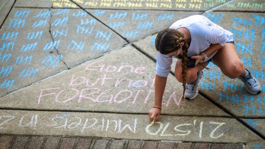 student uses chalk on the sidewalk