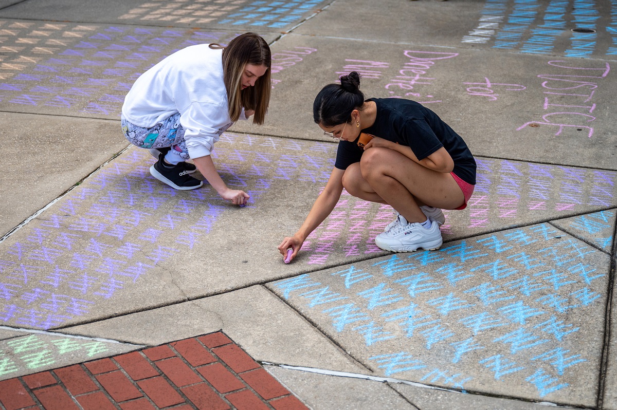 students use chalk on the sidewalk