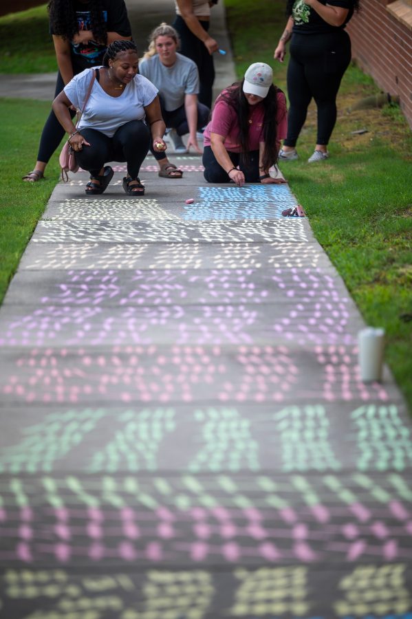 students use chalk on the sidewalk