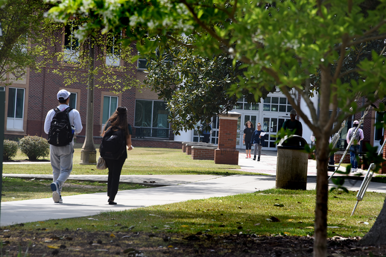 people walking outside on a sidewalk