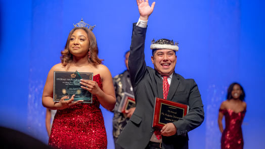 man and woman with awards and wearing a crown at a scholarship competition