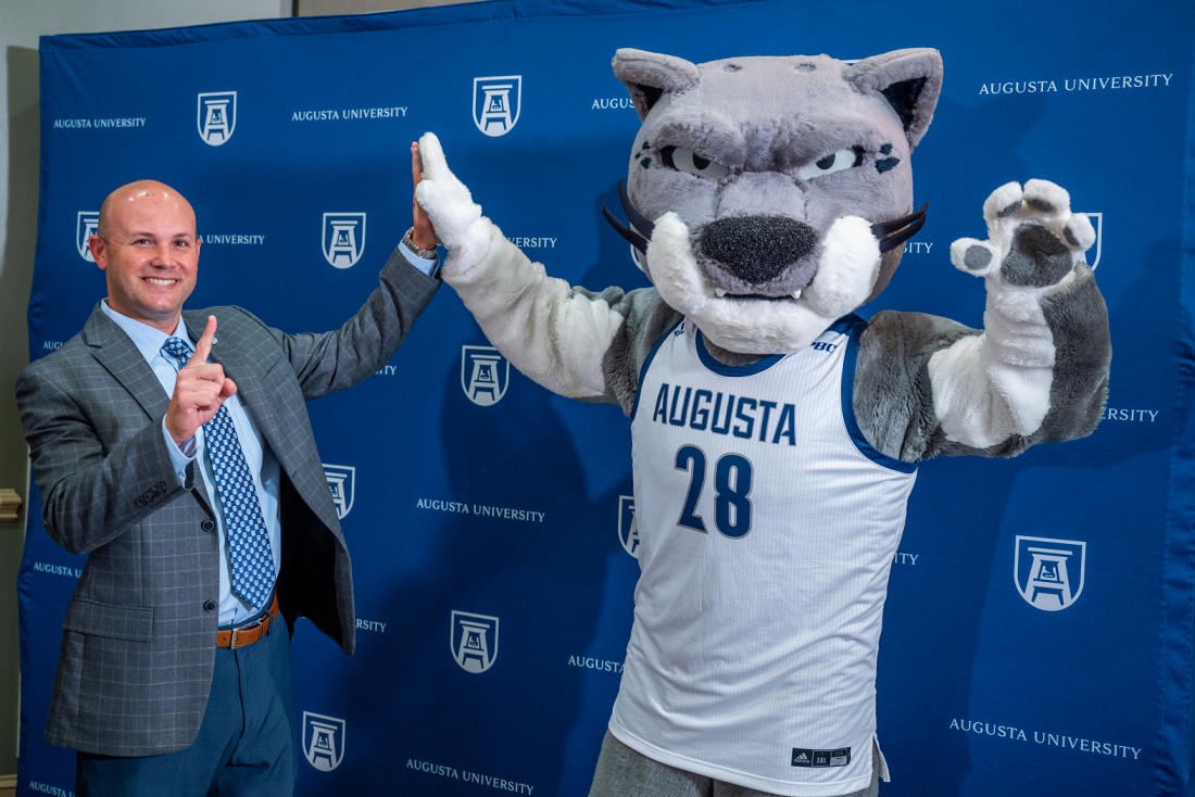 man high-fives with mascot
