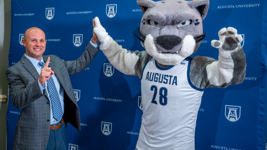 man high-fives with mascot