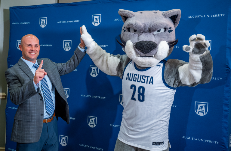 man high-fives with mascot