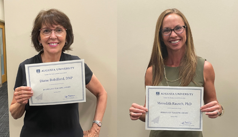 two women holding paper awards
