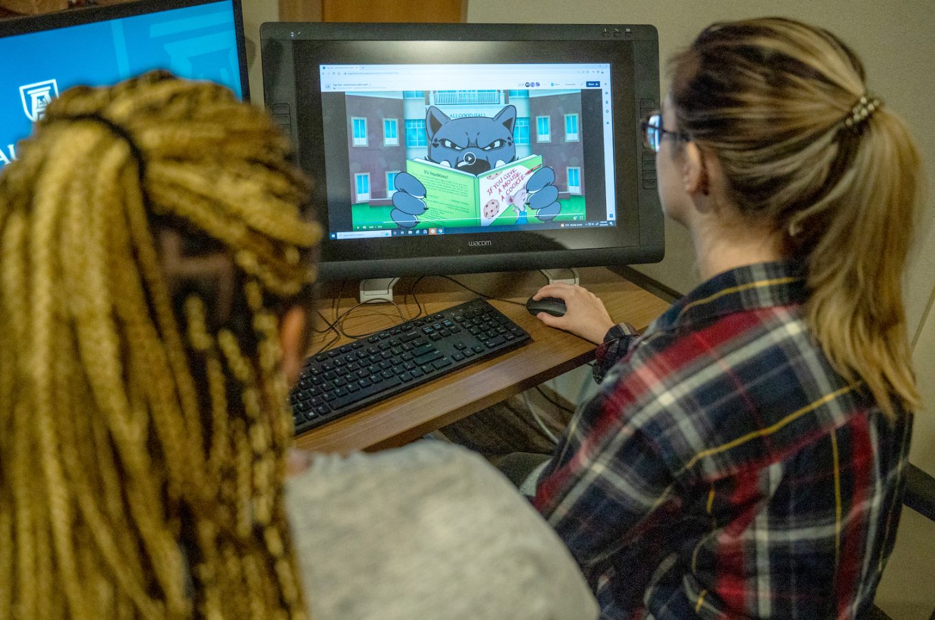 Two students working on a computer.