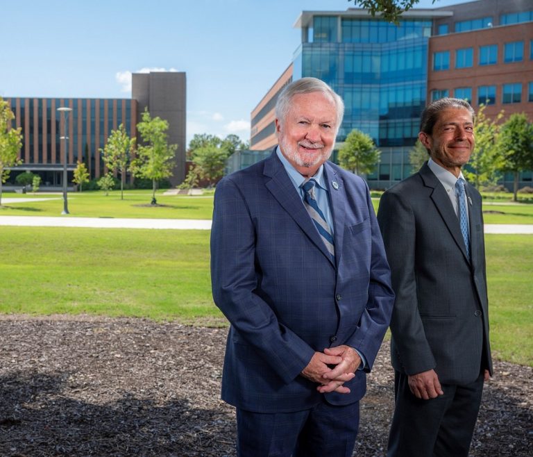 Two men standing outside in front of a building