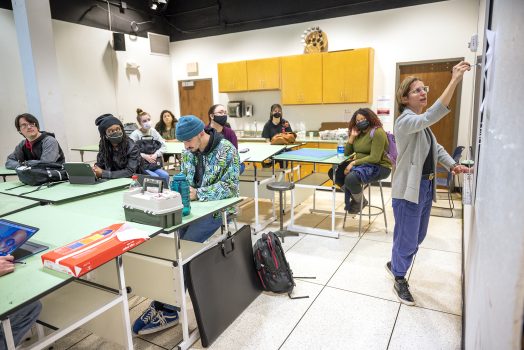 Professor teaching art class full of students