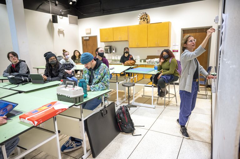 Professor teaching art class full of students