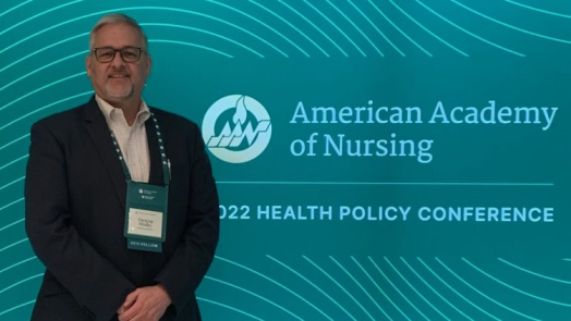 man standing in front of blue background that reads "American Academy of Nursing 2022 Health Policy Conference"