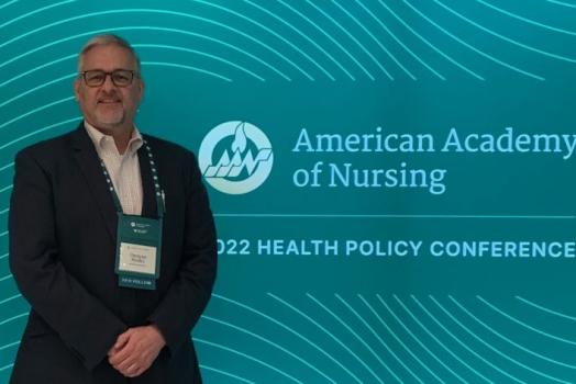 man standing in front of blue background that reads "American Academy of Nursing 2022 Health Policy Conference"