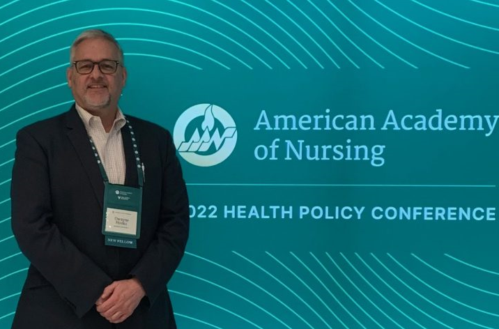 man standing in front of blue background that reads "American Academy of Nursing 2022 Health Policy Conference"