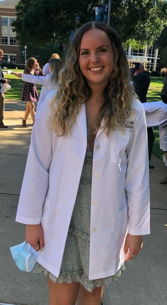 woman in white coat standing outside