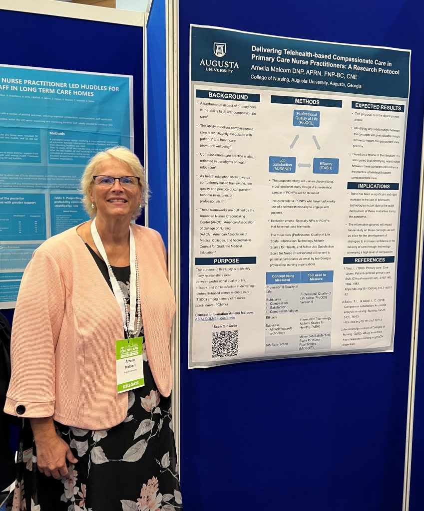 woman at conference, standing in front of her poster