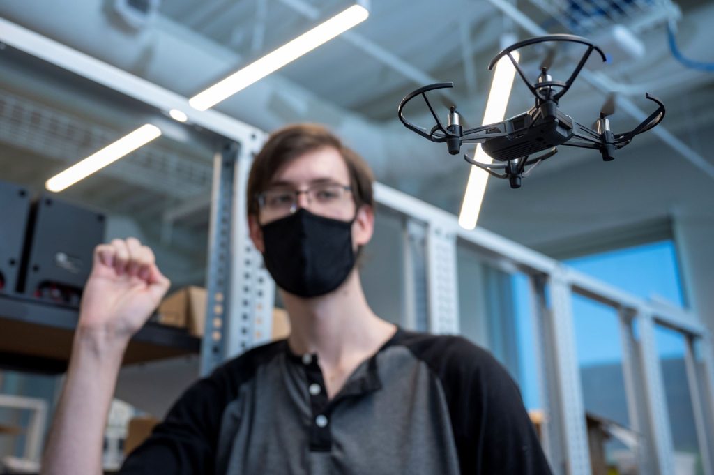 man wearing mask and looking at a small drone