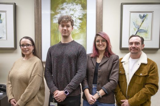 four students standing in a hallway