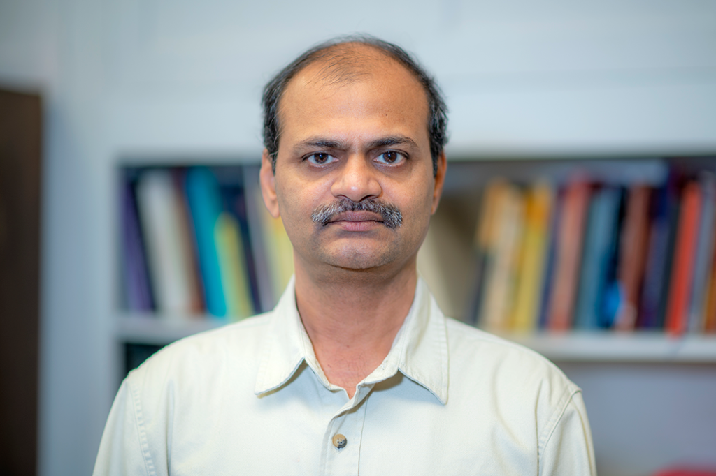 man standing in front of a bookcase