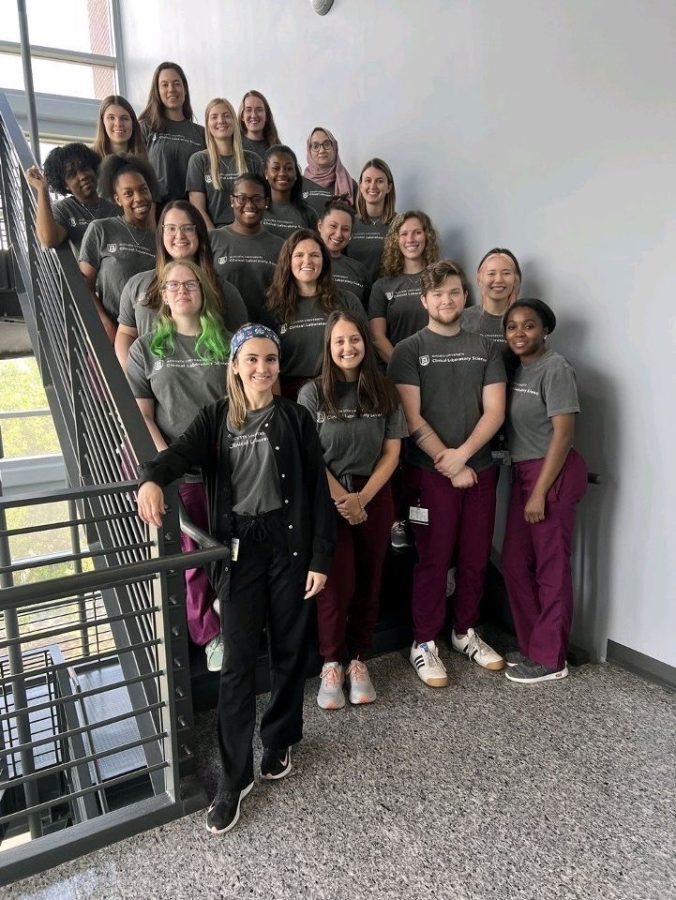 Men and women lab students standing on a staircase