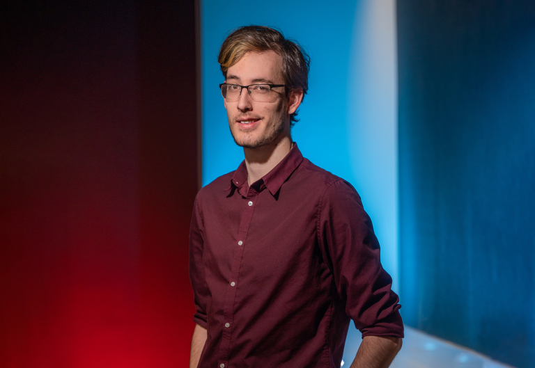 man smiling in red shirt