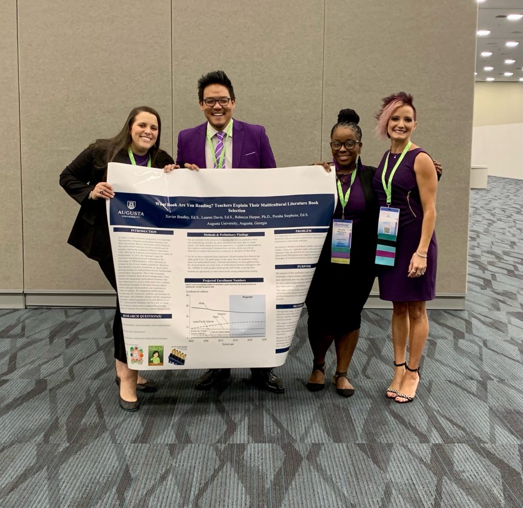 three women and a man at a conference with a poster