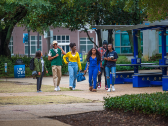 Five students walking outside on the Health Sciences Campus at Augusta University.