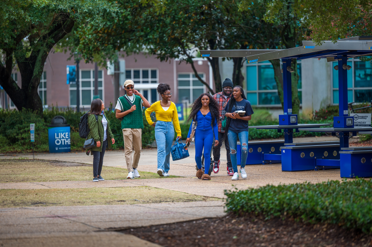 Five students walking outside on the Health Sciences Campus at Augusta University.