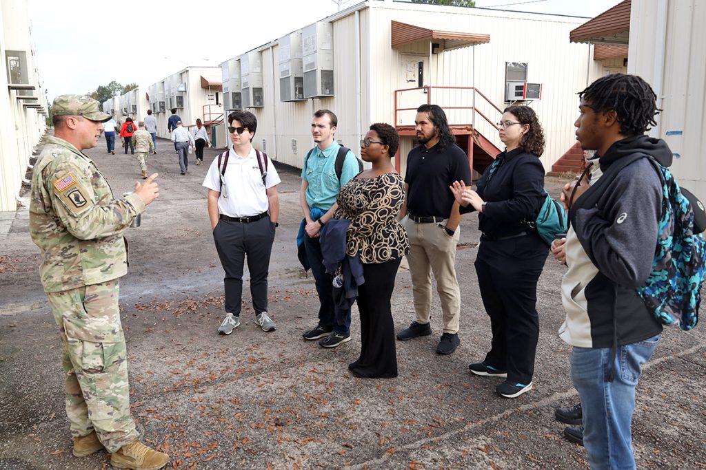 Small group of people speak with a solder.