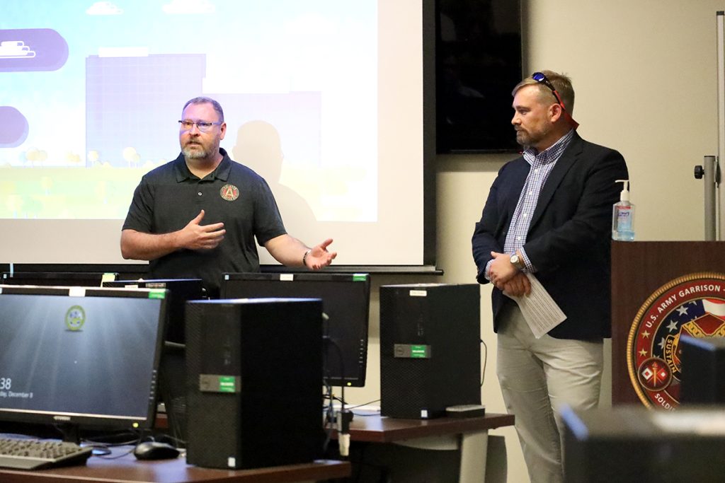 Two men present to a group in a computer lab.