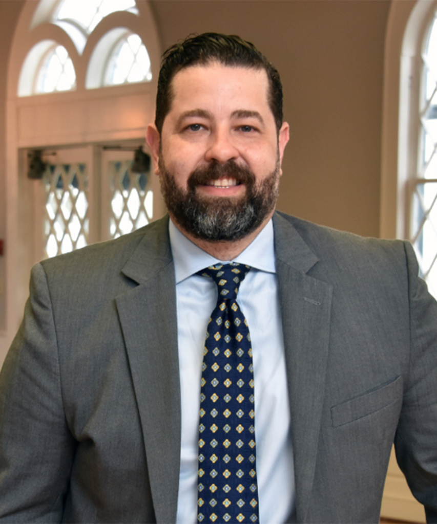 man wearing suit and tie smiling