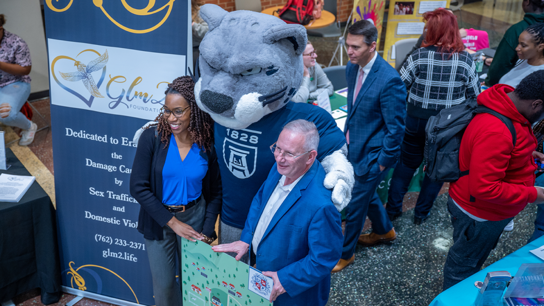 woman and man posing with Augusta University mascot Augustus