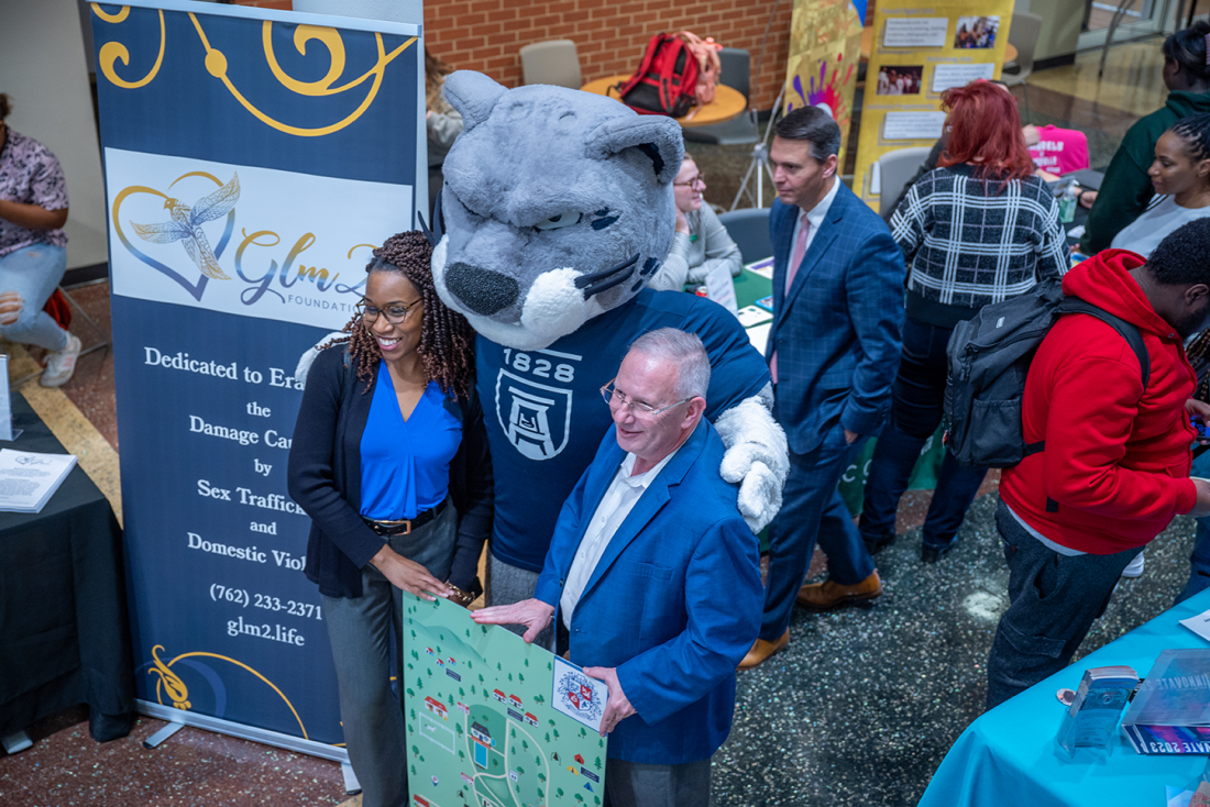 woman and man posing with Augusta University mascot Augustus