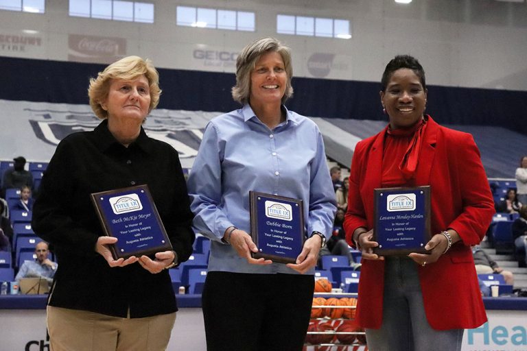 Three women holding plaques
