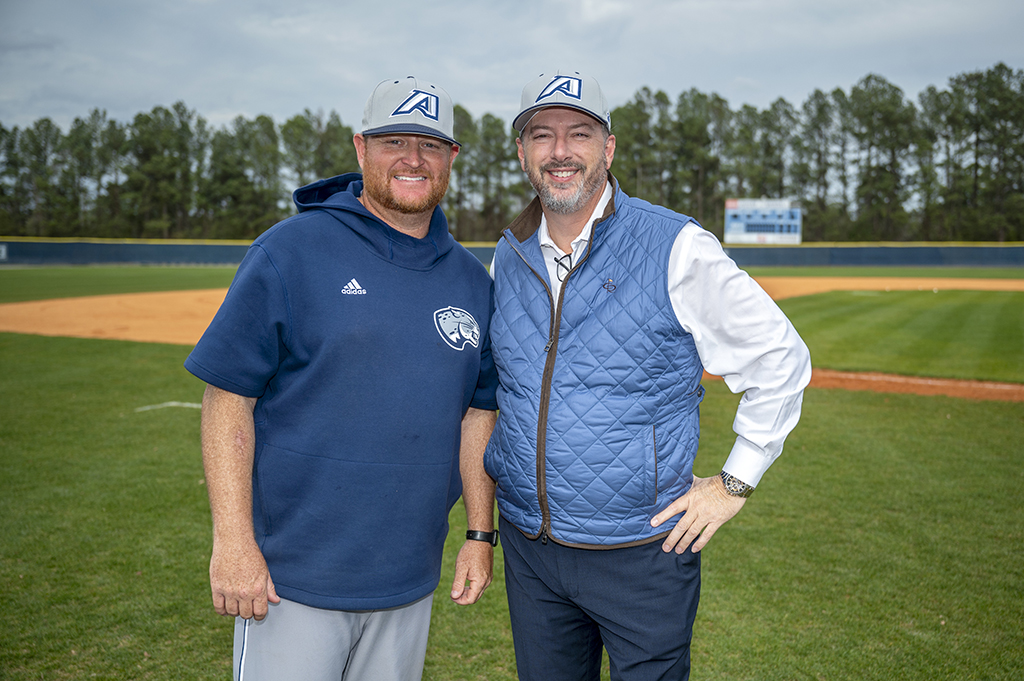 Two men smiling on a baseball field