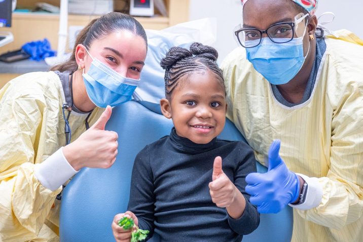 Dr. Ana Phillips and dental assistant Ashley Roberts pose for a photo with their patient.