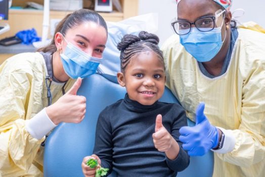 Dr. Ana Phillips and dental assistant Ashley Roberts pose for a photo with their patient.