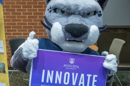 Jaguar mascot holding a sign