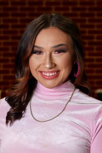 woman smiling in pink blouse