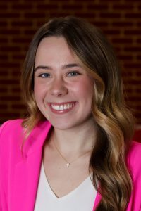 woman wearing a pink blazer and smiling