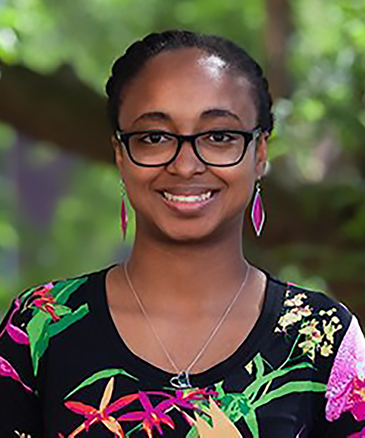 woman with glasses smiling while outside