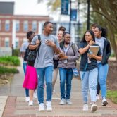 Group of college students walking outside on campus