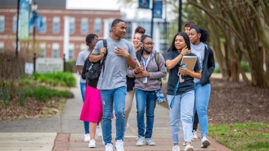 Group of college students walking outside on campus