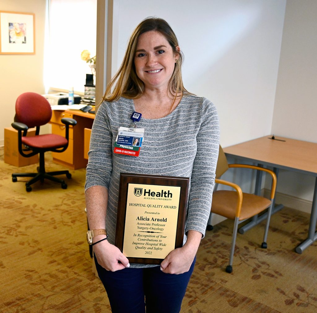 woman standing with an award
