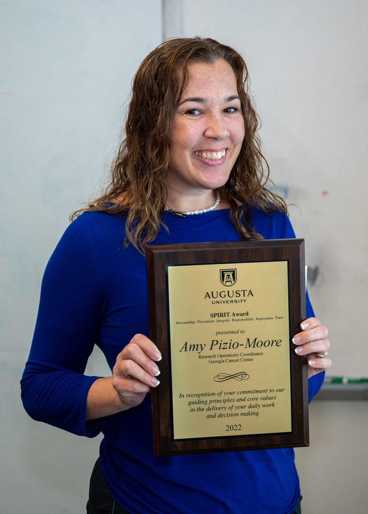 woman standing with an award
