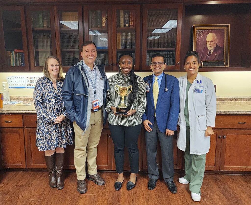 Group of people standing with a trophy
