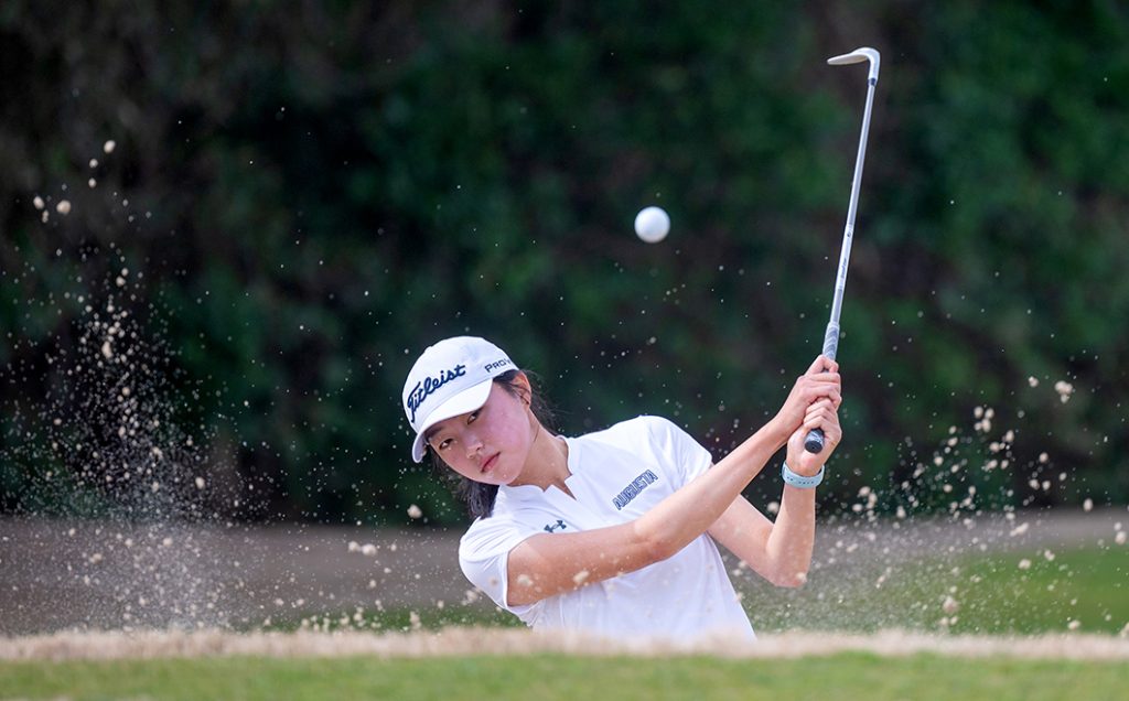 Women swinging a golf club