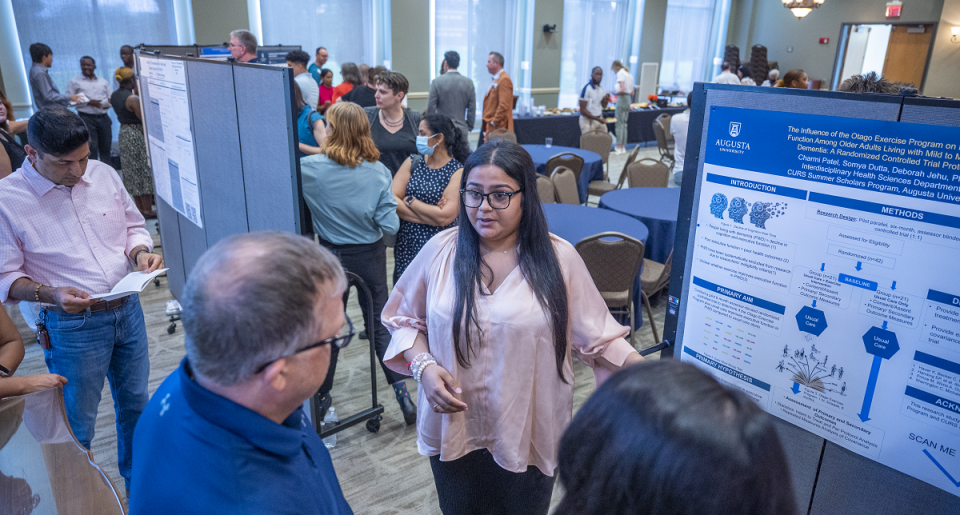 young women presenting to a few people
