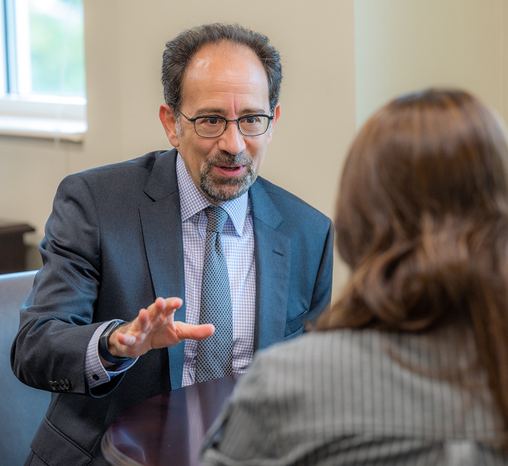 A man speaks with a woman in an office 