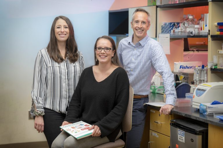 Eric Belin de Chantemele, right, along with Dr. Jessica Faulkner, left, and Candee Barris pose to be photographed in their lab.